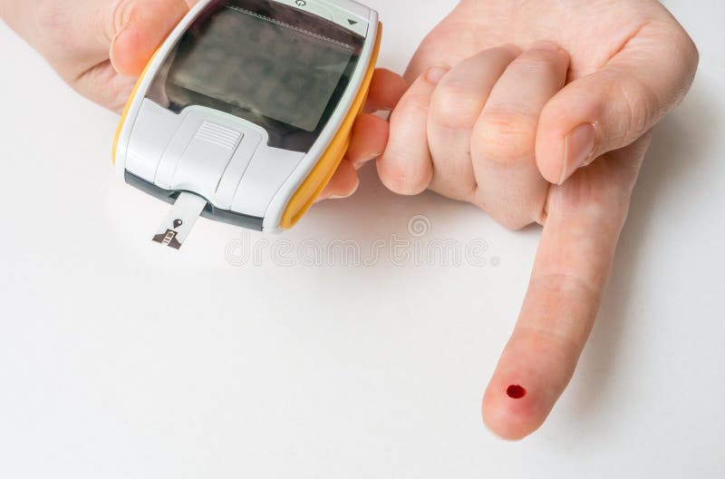 Le patient diabétique a la baisse de sang sur le doigt et mesure le glucometer images libres de droits Le patient diabétique a la baisse de sang sur le doigt et mesure le glucometer images libres de droits
