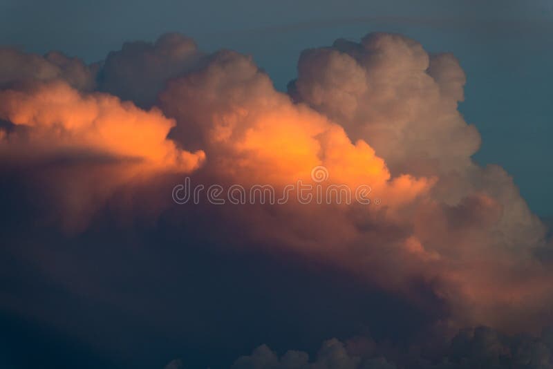 Le paysage nuageux des nuages d'orage moelleux illuminés par des teintes de jaune, d'orange, de rose et de violet à la lumière du image stock Le paysage nuageux des nuages d'orage moelleux illuminés par des teintes de jaune, d'orange, de rose et de violet à la lumière du image stock