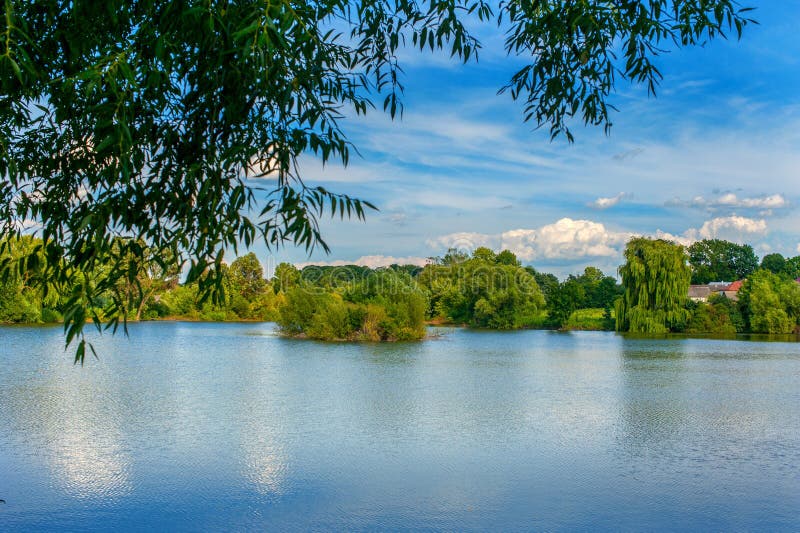 Le paysage tranquille à un lac, avec le ciel vibrant et nettoient l'eau bleue images libres de droits Le paysage tranquille à un lac, avec le ciel vibrant et nettoient l'eau bleue images libres de droits