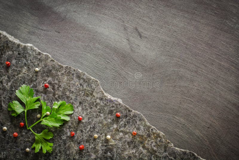 Le persil part sur une pierre polie foncée avec une fracture irrégulière Dans la perspective du bois d'ébène image libre de droits Le persil part sur une pierre polie foncée avec une fracture irrégulière Dans la perspective du bois d'ébène image libre de droits