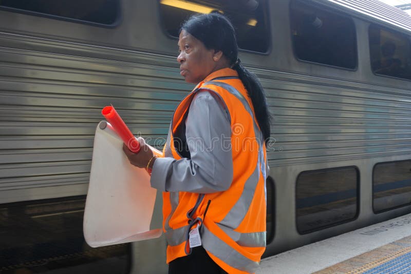 Le personnel de station ondule le drapeau blanc de départ à la garde d'un train de attente en station de Sydney Central Railway photo libre de droits Le personnel de station ondule le drapeau blanc de départ à la garde d'un train de attente en station de Sydney Central Railway photo libre de droits