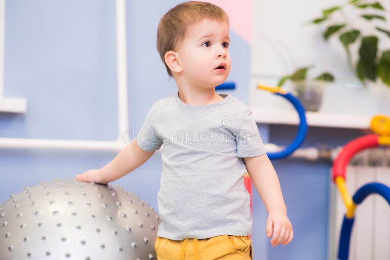 Le petit b?b? joue avec un fitball dans le gymnase photo stock Le petit b?b? joue avec un fitball dans le gymnase photo stock
