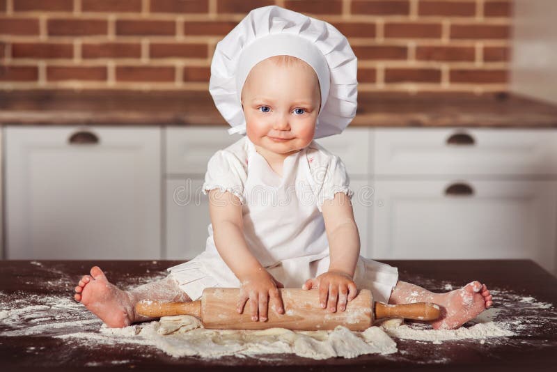 Le Petit Boulanger De Sourire De Bebe Dans Le Chapeau Et Le Tablier Blancs De Cuisinier Malaxe Une Pate Photo Stock Image Du Farine Fille Le Petit Boulanger De Sourire De Bebe Dans Le Chapeau Et Le Tablier Blancs De Cuisinier Malaxe Une Pate Photo Stock Image Du Farine Fille