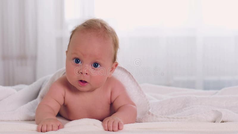 Le petit bébé adorable se trouve sur le ventre banque de vidéos