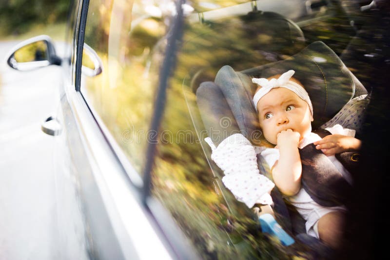 Le petit bébé a attaché avec la ceinture de sécurité dans le siège de voiture de sécurité