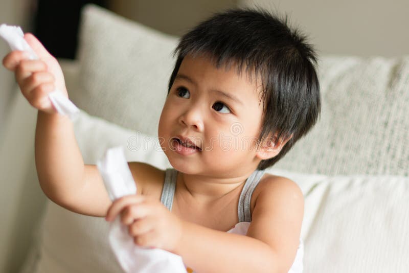 Le petit enfant asiatique remet tirer et partager le papier de soie de soie blanc photos stock Le petit enfant asiatique remet tirer et partager le papier de soie de soie blanc photos stock
