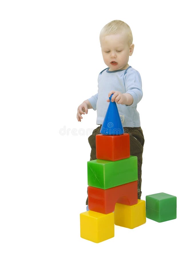 The small child building a tower from cubes. Isolated on a white background. The small child building a tower from cubes. Isolated on a white background.