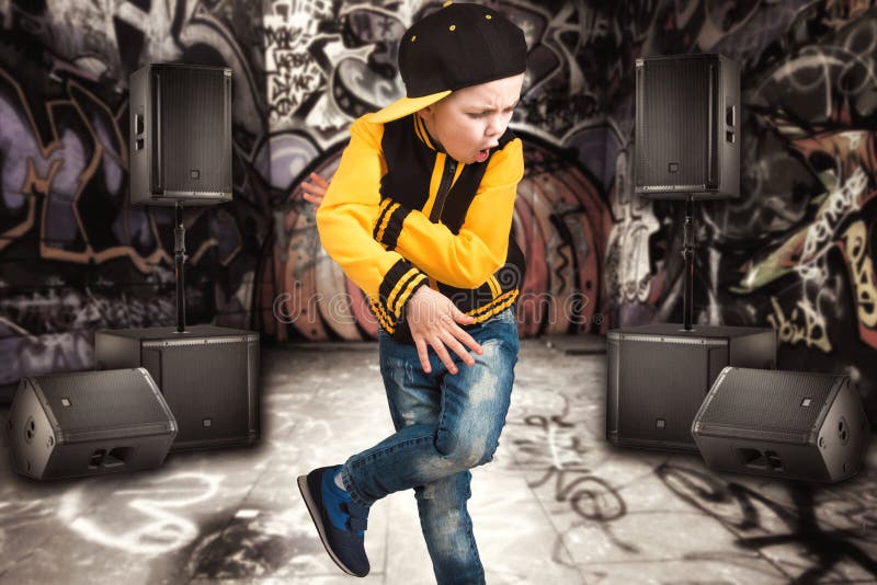 Le petit garçon dans le style du hip-hop Mode du ` s d'enfants Chapeau et veste Le jeune frappeur Graffiti sur les murs Refroidis images stock Le petit garçon dans le style du hip-hop Mode du ` s d'enfants Chapeau et veste Le jeune frappeur Graffiti sur les murs Refroidis images stock