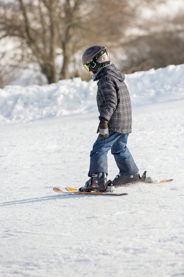 Le petit garçon dans le masque et le casque de ski apprend le ski image libre de droits Le petit garçon dans le masque et le casque de ski apprend le ski image libre de droits
