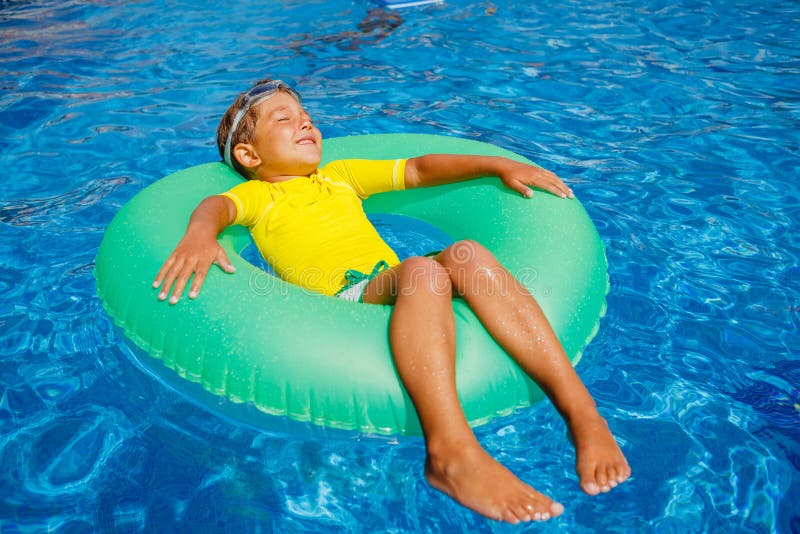 Le petit garçon détendent dans la piscine photographie stock Le petit garçon détendent dans la piscine photographie stock