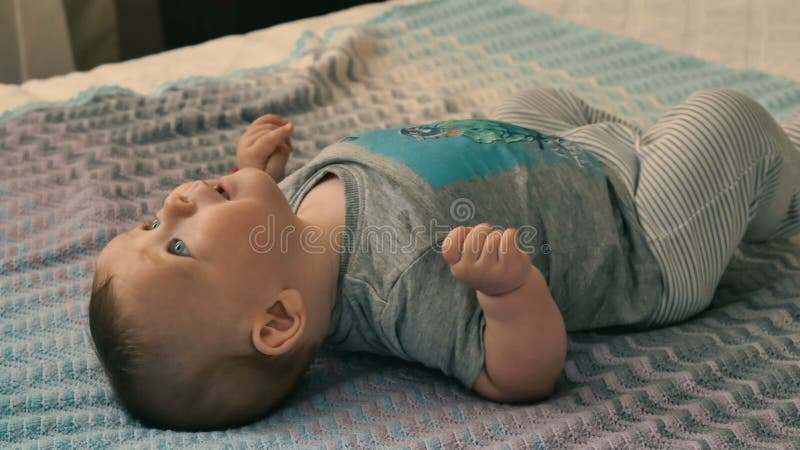 Le petit garçon mignon se trouve sur le lit