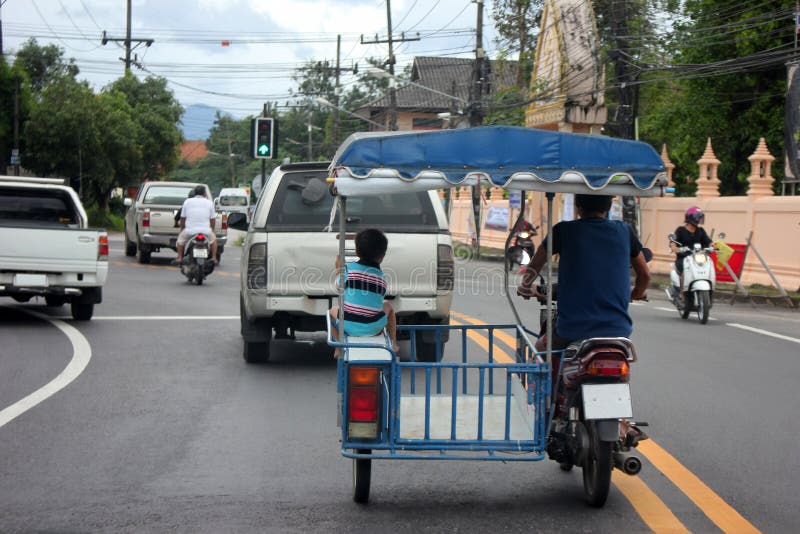 Le petit garçon s'asseyant dans les gens du pays a modifié la moto sur les routes images libres de droits Le petit garçon s'asseyant dans les gens du pays a modifié la moto sur les routes images libres de droits