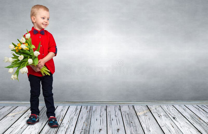 Le petit garçon élégant tient un bouquet des tulipes de ressort Ressort, vacances, la mode des enfants photos libres de droits Le petit garçon élégant tient un bouquet des tulipes de ressort Ressort, vacances, la mode des enfants photos libres de droits