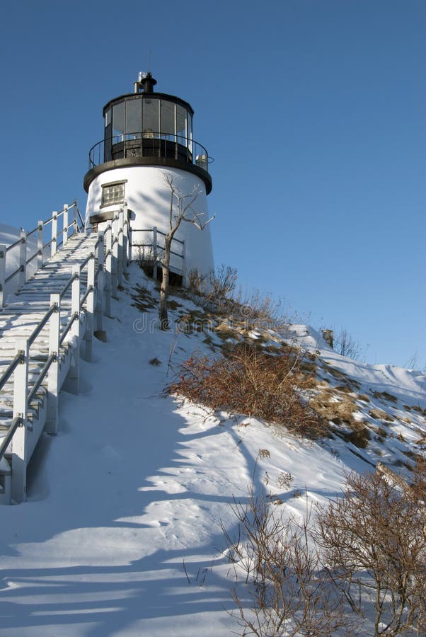 Le phare sur la neige a couvert la falaise photos stock Le phare sur la neige a couvert la falaise photos stock