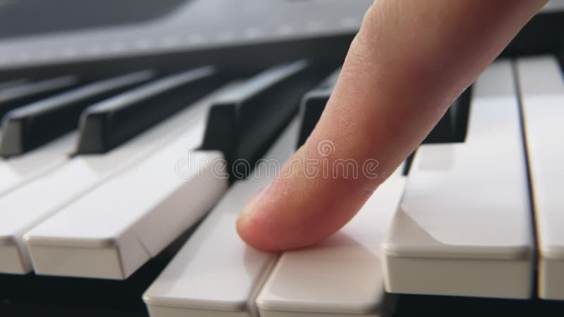 Le pianiste passe son doigt sur les touches blanches du piano. quelqu'un passe le doigt sur les clés du synthétiseur électronique