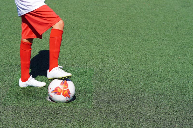 Le pied d'un garçon de prédilection marchant sur le ballon de football avant de prendre une balle de pénalité photos libres de droits