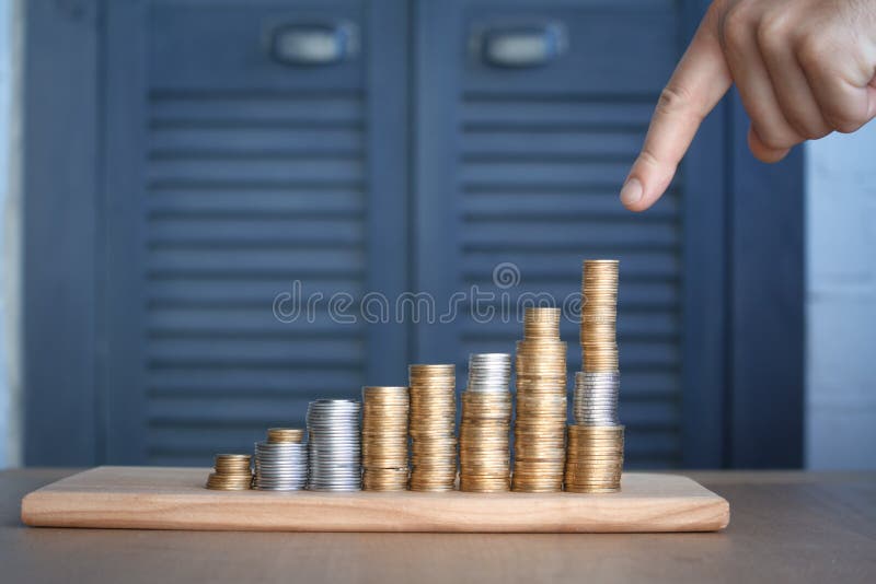 Le plan rapproché d'a équipe la main se dirigeant aux colonnes des pièces de monnaie multicolores de la taille croissante, du con photographie stock libre de droits Le plan rapproché d'a équipe la main se dirigeant aux colonnes des pièces de monnaie multicolores de la taille croissante, du con photographie stock libre de droits