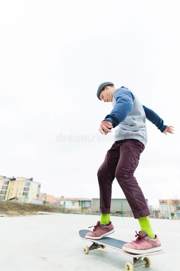 Le planchiste d'adolescent monte le skatepark par temps nuageux Culture urbaine de la jeunesse images stock Le planchiste d'adolescent monte le skatepark par temps nuageux Culture urbaine de la jeunesse images stock