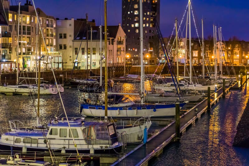 Le port du vlissingen la nuit avec beaucoup de bateaux accouplés, bateaux décorés avec les lumières, bâtiments allumés de ville a photographie stock Le port du vlissingen la nuit avec beaucoup de bateaux accouplés, bateaux décorés avec les lumières, bâtiments allumés de ville a photographie stock
