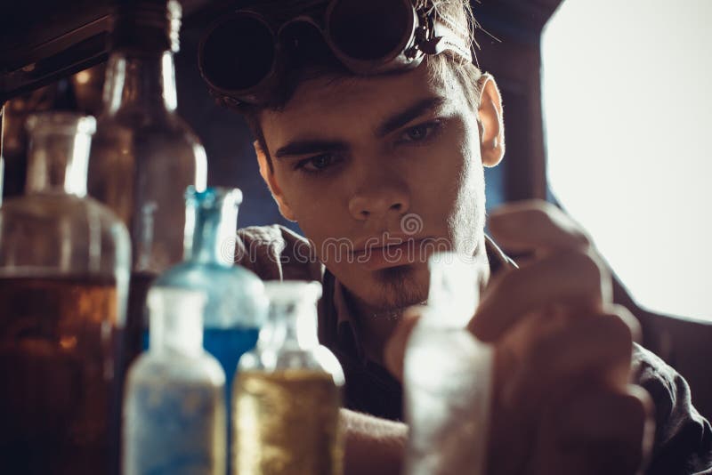 Le portrait d'un jeune scientifique fou s'est habillé dans le style de steampunk et photo stock Le portrait d'un jeune scientifique fou s'est habillé dans le style de steampunk et photo stock