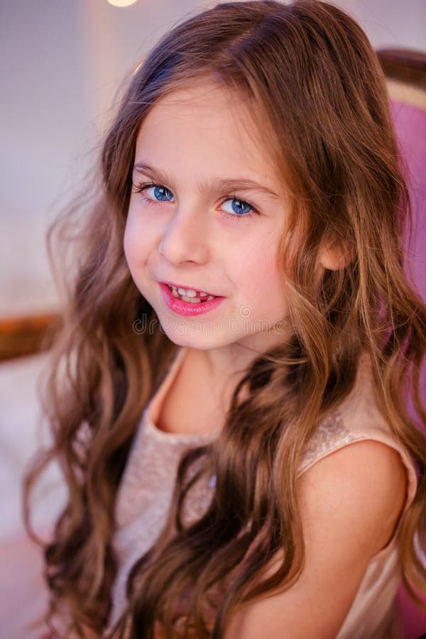 Le portrait d'une petite fille avec les cheveux bouclés le réveillon de Noël, la nouvelle année apportera des cadeaux images libres de droits Le portrait d'une petite fille avec les cheveux bouclés le réveillon de Noël, la nouvelle année apportera des cadeaux images libres de droits