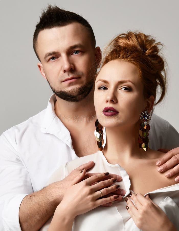 Le portrait de jeunes couples élégants dans la position officielle de vêtements avèrent le fond gris photos libres de droits Le portrait de jeunes couples élégants dans la position officielle de vêtements avèrent le fond gris photos libres de droits