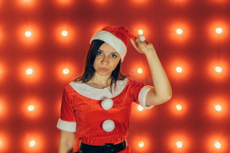 Le portrait de la belle fille sexy portant Santa Claus vêtx sur le fond rouge photographie stock Le portrait de la belle fille sexy portant Santa Claus vêtx sur le fond rouge photographie stock