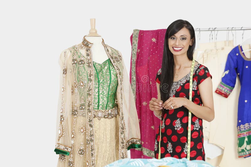 Le portrait de la couturière féminine indienne se tenant prêt un simulacre s'est habillé dans l'usage traditionnel image libre de droits Le portrait de la couturière féminine indienne se tenant prêt un simulacre s'est habillé dans l'usage traditionnel image libre de droits
