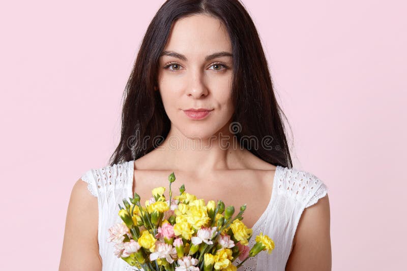 Le portrait de la jeune dame de brune douce, habillé dans la robe blanche, reçoit le cadeau sur l'anniversaire, étant photographi image stock Le portrait de la jeune dame de brune douce, habillé dans la robe blanche, reçoit le cadeau sur l'anniversaire, étant photographi image stock