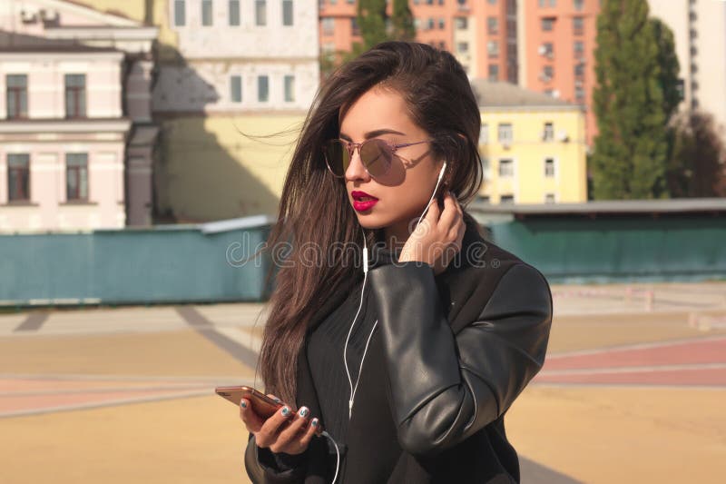 Le portrait de plan rapproché de la belle femme de brune écoutent musique sur la foule photographie stock libre de droits Le portrait de plan rapproché de la belle femme de brune écoutent musique sur la foule photographie stock libre de droits