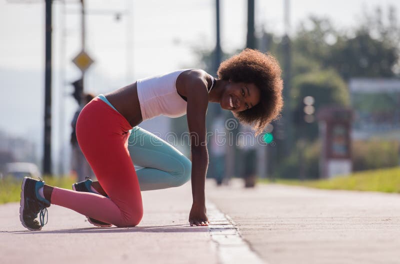 Le portrait du jeune étirage sportif de femme d'afro-américain se surpassent images stock Le portrait du jeune étirage sportif de femme d'afro-américain se surpassent images stock