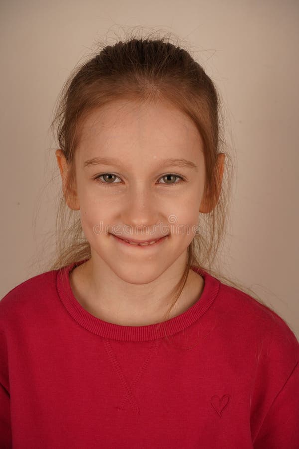 Le portrait montre un portrait d'une jeune fille rayonnant sourire. Son visage enfantin sincère rayonne de chaleur et image libre de droits