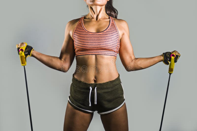 Le portrait sans visage de la femme d'ajustement de jeunes et de sport sportif travaillant dur avec la résistance élastique se ré image libre de droits Le portrait sans visage de la femme d'ajustement de jeunes et de sport sportif travaillant dur avec la résistance élastique se ré image libre de droits