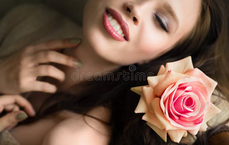 Le portrait étroit de la belle jeune femme dans le lit avec s'est levé image libre de droits Le portrait étroit de la belle jeune femme dans le lit avec s'est levé image libre de droits