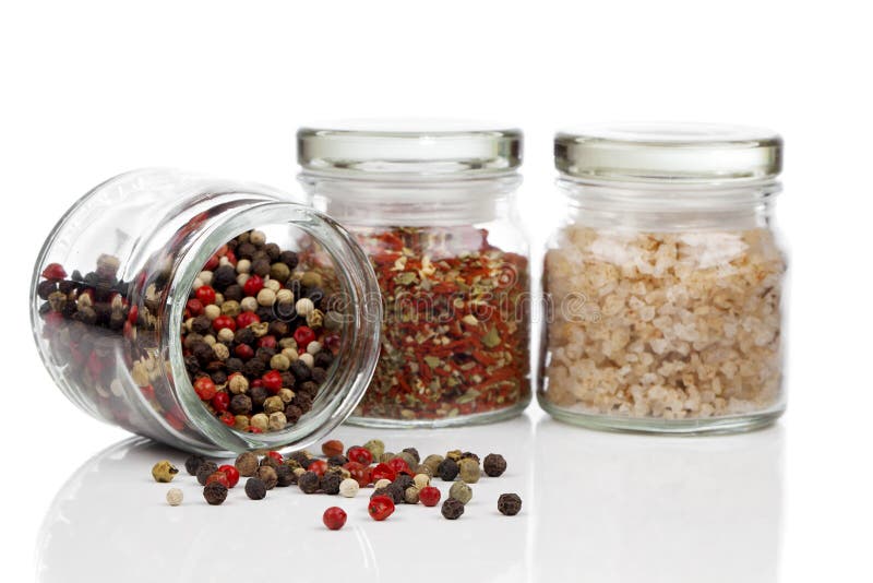 Glass jar with Colored Peppers Mix, red chili pepper and salt, on white background. Glass jar with Colored Peppers Mix, red chili pepper and salt, on white background