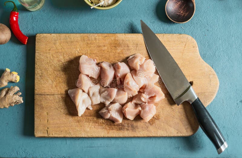 Le poulet rapièce sur la planche à découper avec le couteau sur la table de cuisine, vue supérieure photos libres de droits