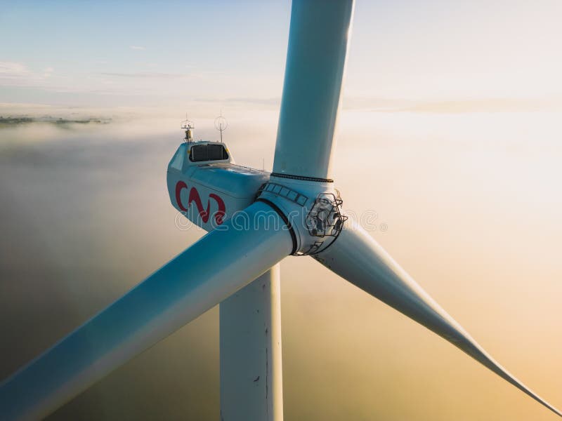 Le Pouzin, France - 2 Octobre, 2022: Close-up on the propellers of a wind turbine during a misty morning and sunrise.