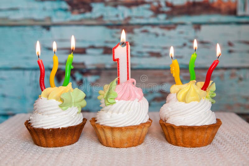 Le premier gâteau d'anniversaire heureux et numéro une bougie sur le fond bleu photo libre de droits Le premier gâteau d'anniversaire heureux et numéro une bougie sur le fond bleu photo libre de droits
