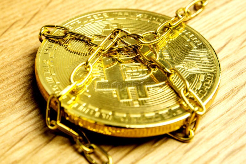 Closeup of golden bitcoin in golden chains laying on wooden background. Closeup of golden bitcoin in golden chains laying on wooden background
