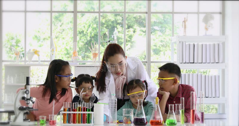 Le professeur enseignent des? tudiants au sujet des produits chimiques dans le laboratoire banque de vidéos