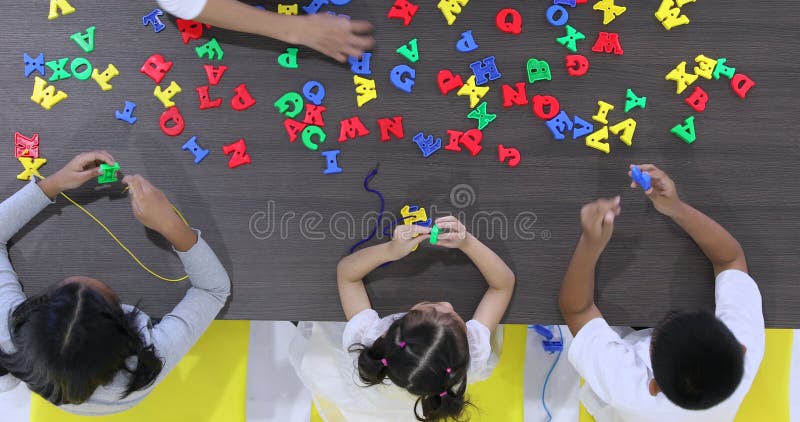 Le professeur laisse le jouet d'alphabet de ficelle d'?tudiant ensemble