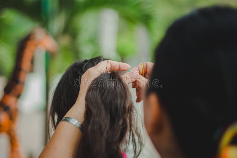 Le professeur prépare les cheveux du ` s d'étudiant avant de renvoyer la maison photos libres de droits Le professeur prépare les cheveux du ` s d'étudiant avant de renvoyer la maison photos libres de droits