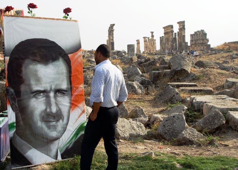 The portrait of President Bashar al-Assad is ubiquitous across Syria and is here pitcured against the dramatic backdrop of the columns of the ruined ancient roman city of Apemea. The portrait of President Bashar al-Assad is ubiquitous across Syria and is here pitcured against the dramatic backdrop of the columns of the ruined ancient roman city of Apemea