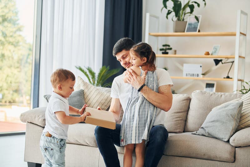 Le père en civil est à la maison avec sa fille et son fils photographie stock libre de droits