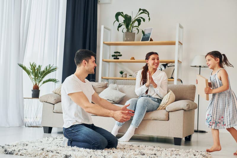 Le père en vêtements décontractés est à la maison avec sa femme et sa fille image libre de droits