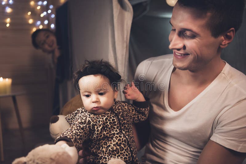 Le père et le fils jouent avec la petite soeur de bébé la nuit à la maison images libres de droits Le père et le fils jouent avec la petite soeur de bébé la nuit à la maison images libres de droits