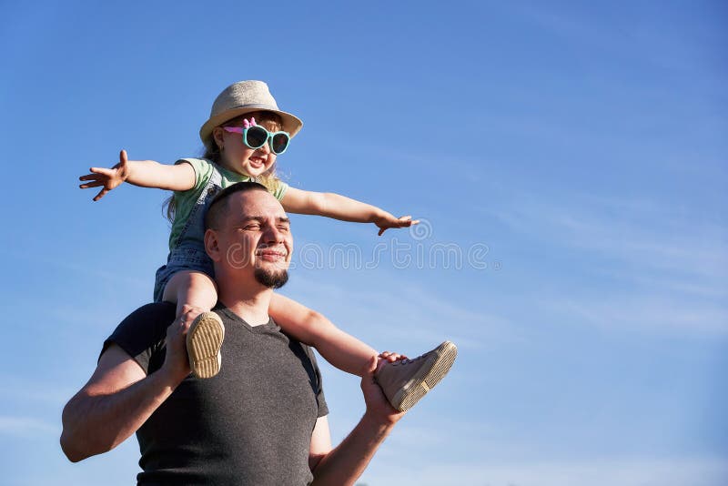 Le père et la fille sur des épaules se réjouissent heureusement papa tenant peu de fille reposant sur des imitateurs le vol du pa image libre de droits Le père et la fille sur des épaules se réjouissent heureusement papa tenant peu de fille reposant sur des imitateurs le vol du pa image libre de droits