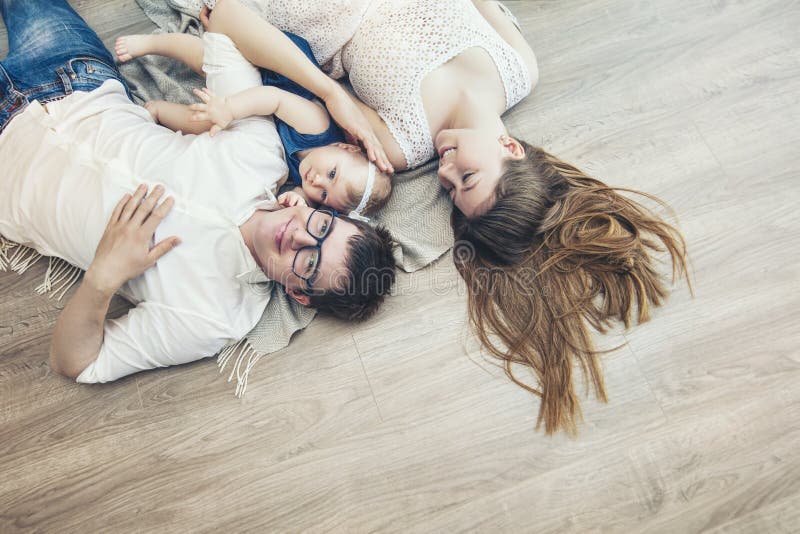 Le père et le bébé de mère de famille sont ensemble à la maison sourire heureux images stock Le père et le bébé de mère de famille sont ensemble à la maison sourire heureux images stock