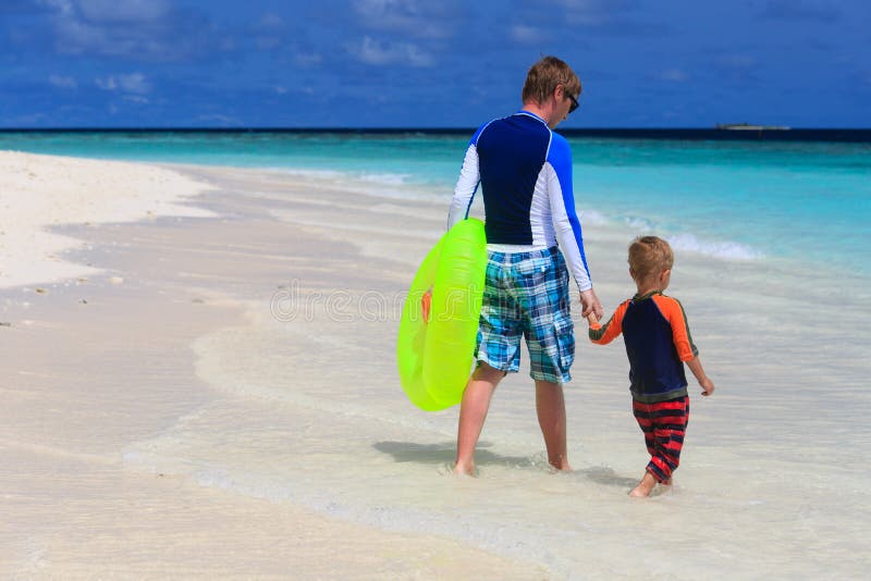Le père et le fils vont nager à la plage image libre de droits Le père et le fils vont nager à la plage image libre de droits