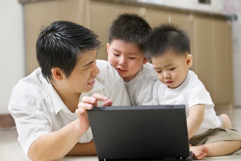 Le père introduisent la technologie à ses fils photos stock Le père introduisent la technologie à ses fils photos stock